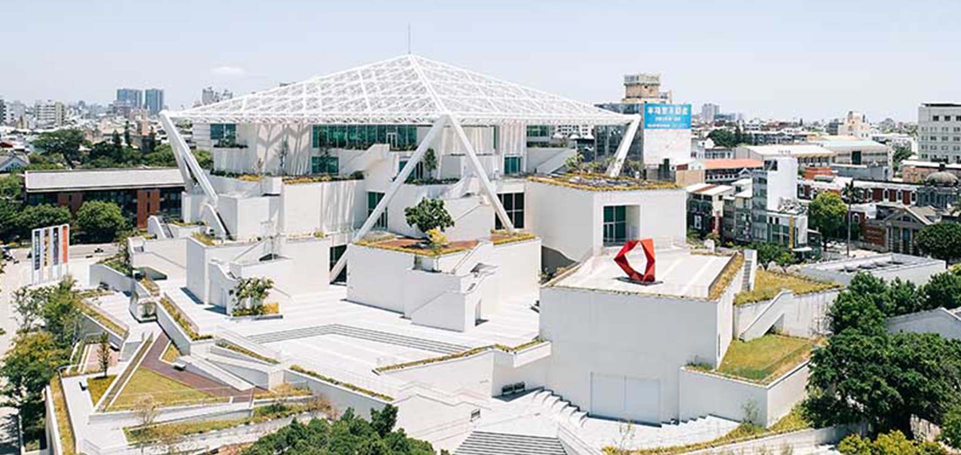 Elevated front view of the modern museum showing its facade, roof canopy, and terraces